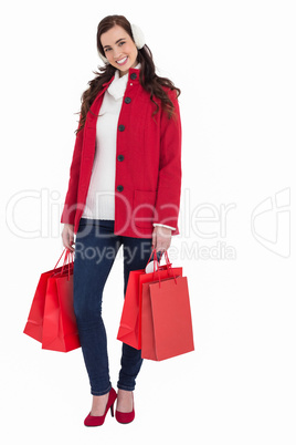 Happy brunette in winter clothes holding shopping bags