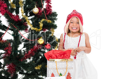 Festive little girl smiling at camera with gifts