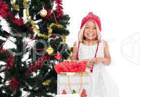 Festive little girl smiling at camera with gifts