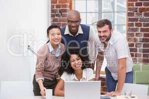 Creative business team using laptop in meeting