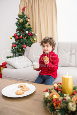 Festive little boy having milk and cookies