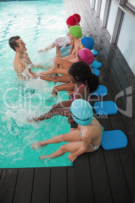 Cute swimming class in pool with coach