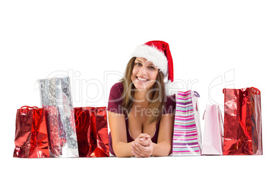 Festive brunette smiling at camera with gift bags