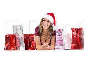 Festive brunette smiling at camera with gift bags