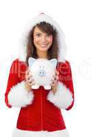 Smiling brunette in santa claus holding a piggy bank