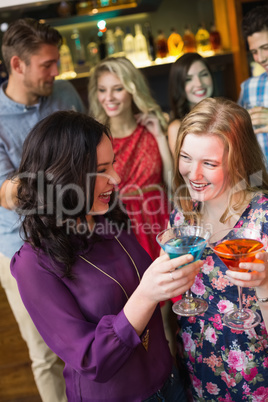 Pretty friends drinking cocktails together