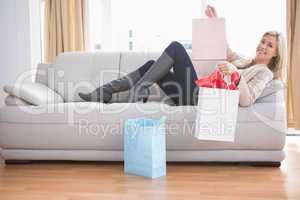 Woman lying on couch with shopping bags