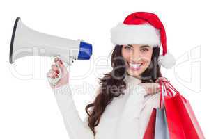 Smiling brunette holding gift bags and megaphone