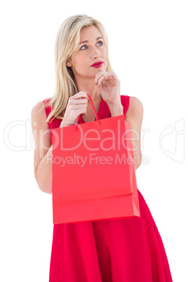 Stylish blonde in red dress opening gift bag