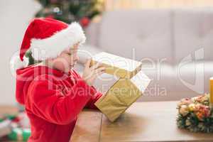 Festive little boy opening a gift