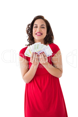 Stylish brunette in red dress holding cash