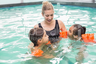 Cute swimming class in pool with coach