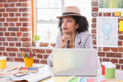 Thoughtful female interior designer at desk