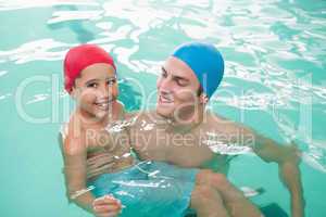 Cute little boy learning to swim with coach