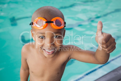 Cute little boy giving thumbs up at the pool