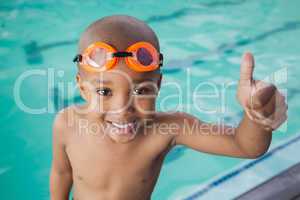 Cute little boy giving thumbs up at the pool