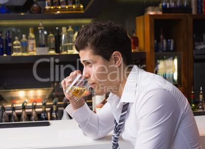 Young man drinking whiskey neat