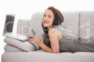 Pretty brunette using her laptop on the couch