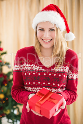 Festive pretty blonde woman offering gift