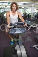 Handsome man working out on exercise bike at gym