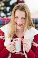 Smiling blonde in winter clothes holding mug