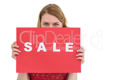 Cute blonde showing a red sale poster