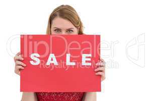 Cute blonde showing a red sale poster