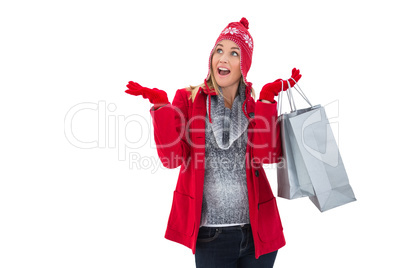 Happy blonde in winter clothes holding shopping bags