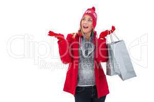 Happy blonde in winter clothes holding shopping bags