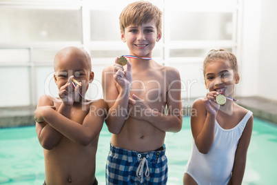 Cute swimming class smiling with medals