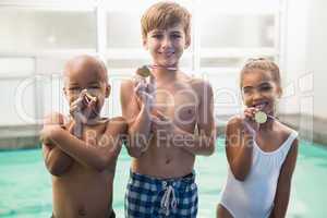 Cute swimming class smiling with medals