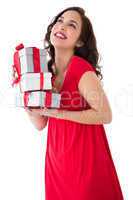 Stylish brunette in red dress holding pile of gifts