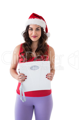 Festive fit brunette holding page and measuring tape