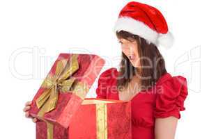 Surprised festive brunette holding a gift