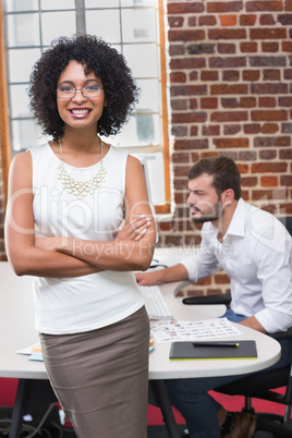 Smiling businesswoman with arms crossed in office