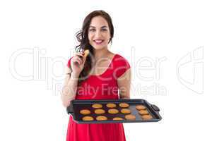 Happy brunette eating hot cookies