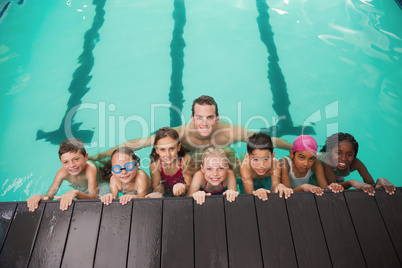 Cute swimming class in pool with coach