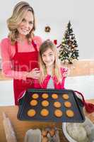 Festive mother and daughter making christmas cookies