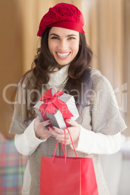 Happy brunette holding gift and shopping bags