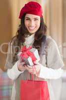 Happy brunette holding gift and shopping bags