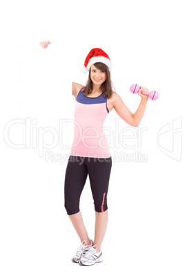 Festive fit brunette smiling at camera holding poster