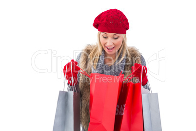 Blonde in winter clothes looking in shopping bags