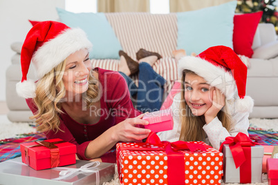 Festive little girl with mother surrounded by gifts