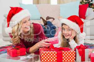 Festive little girl with mother surrounded by gifts