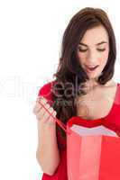 Brunette in red dress looking in shopping bag