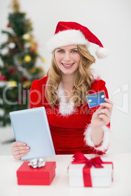 Festive blonde shopping online with tablet