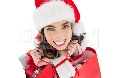 Happy brunette holding shopping bags full of gifts