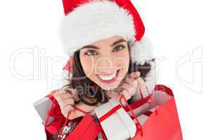 Happy brunette holding shopping bags full of gifts