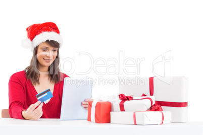 Festive brunette shopping online with tablet pc