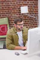 Serious casual young man using computer